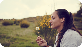a person who is admiring a flower from looking from a side