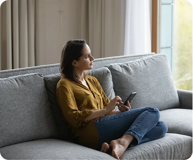 a person sitting on the couch looking at the window